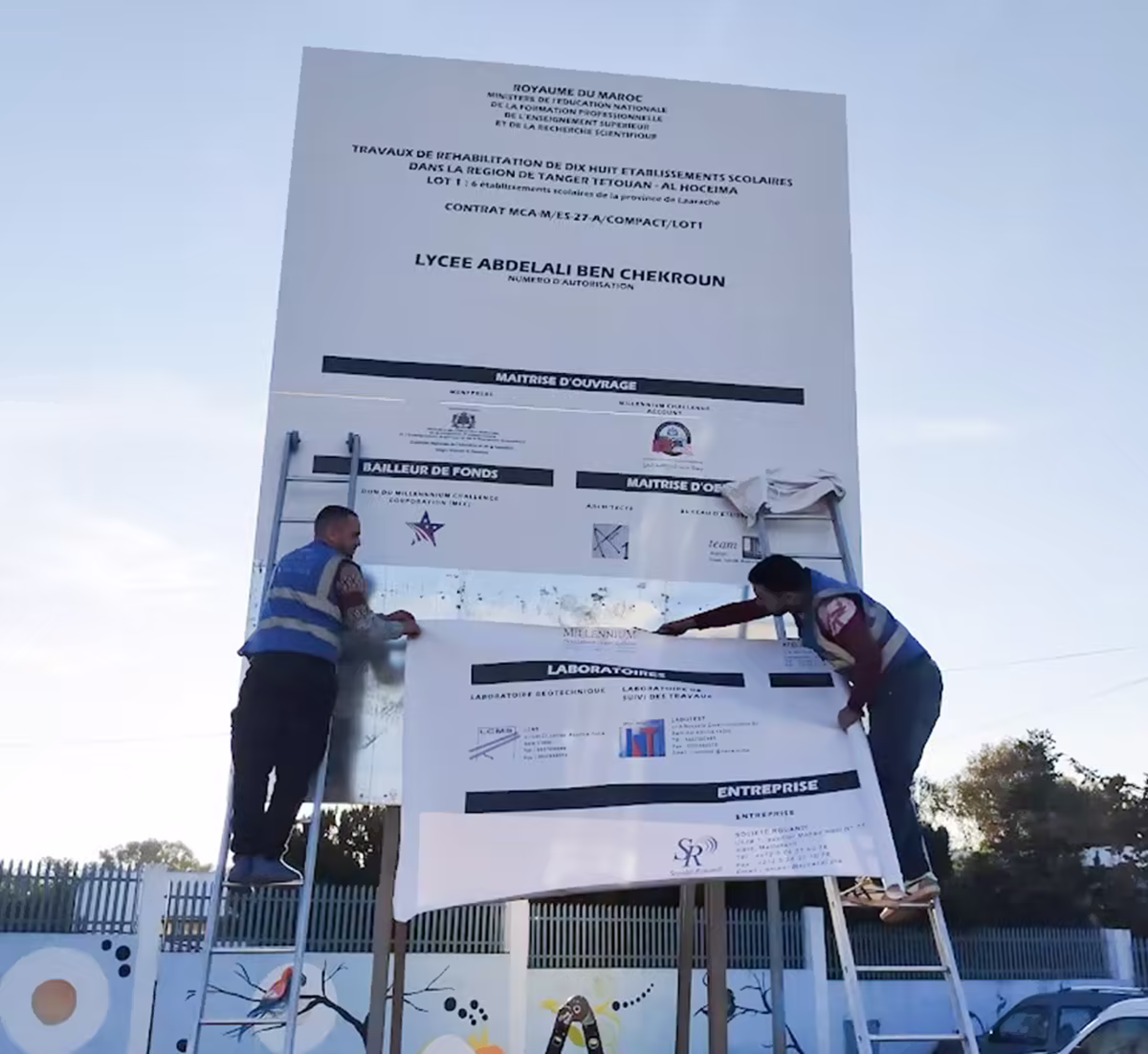 Pose d'un panneau de chantier lycée à Tanger — imprimerie grand format
